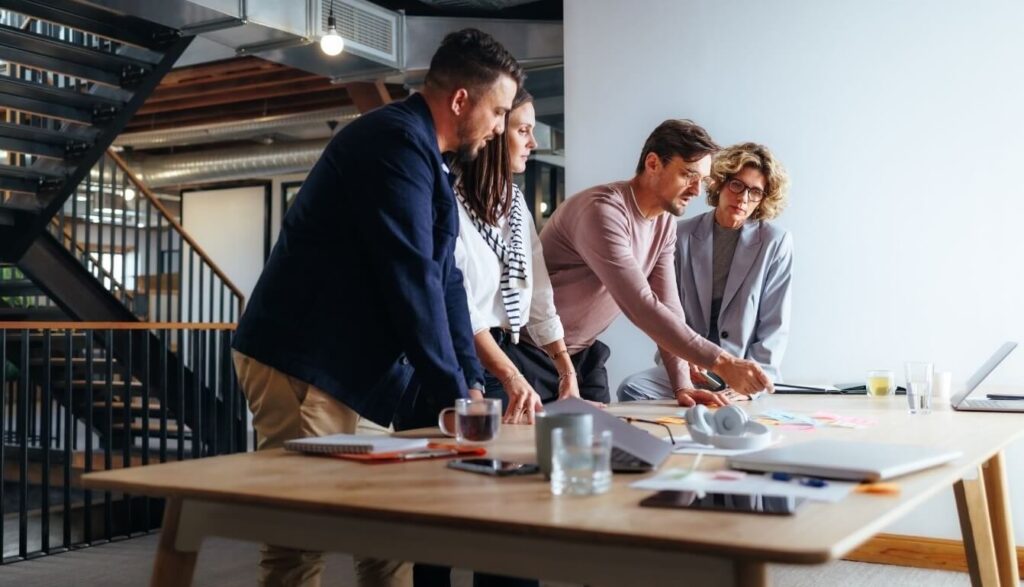 Creative team collaborating around a table, representing virtual finance director support