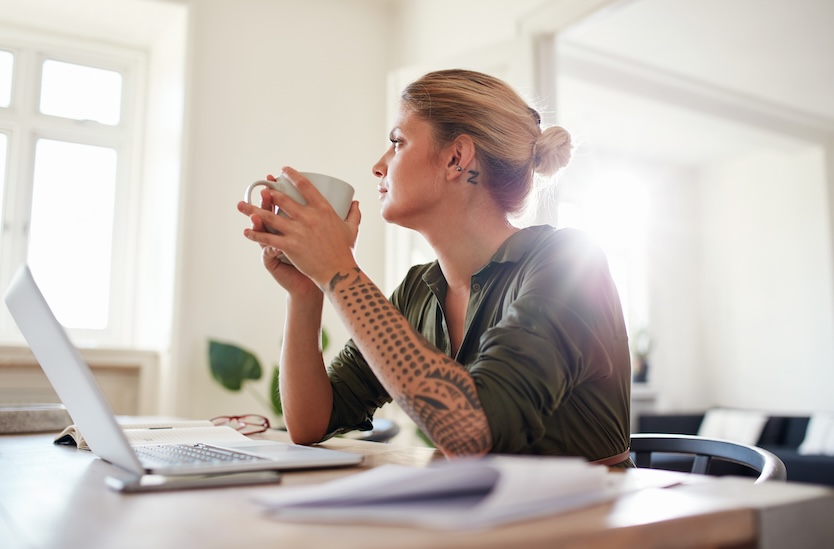Creative business owner reflecting on business growth and future financial planning.
